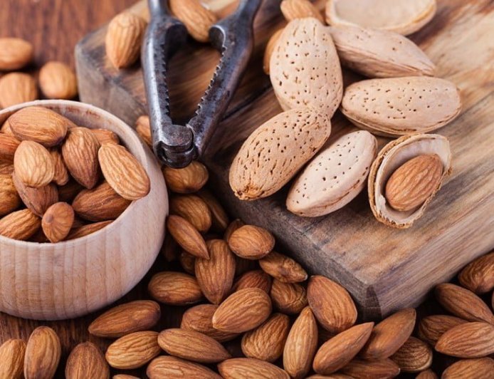 How many kilograms of almonds does a 5-year-old tree produce?